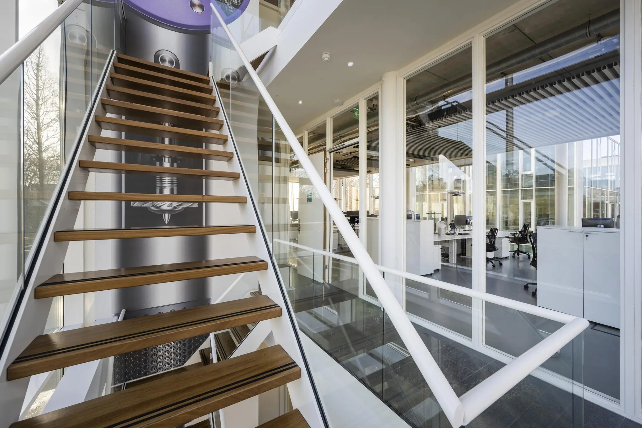 Moderne trap met houten treden in een glazen kantoorgebouw aan de Fred. Roeskestraat.